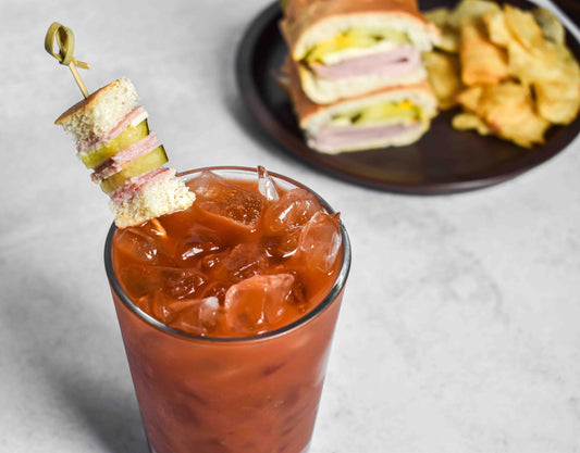 a bloody mary with a small sandwich garnish