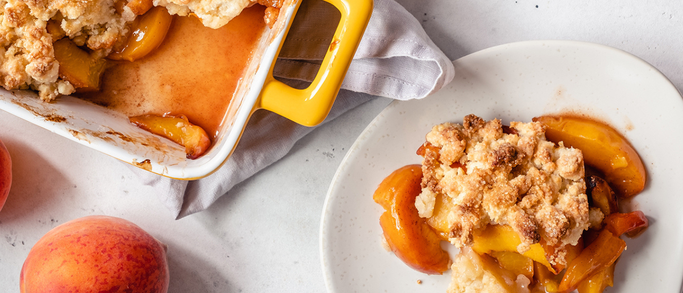 Image of the Altman Farm peach cobbler recipe, served in the dish and on a plate